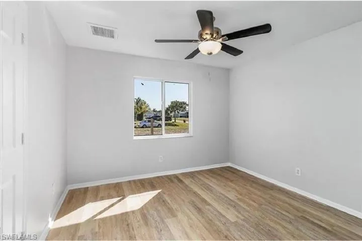 Empty room with wood finished floors and a ceiling fan