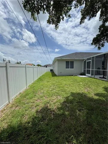 Fenced backyard featuring a sunroom
