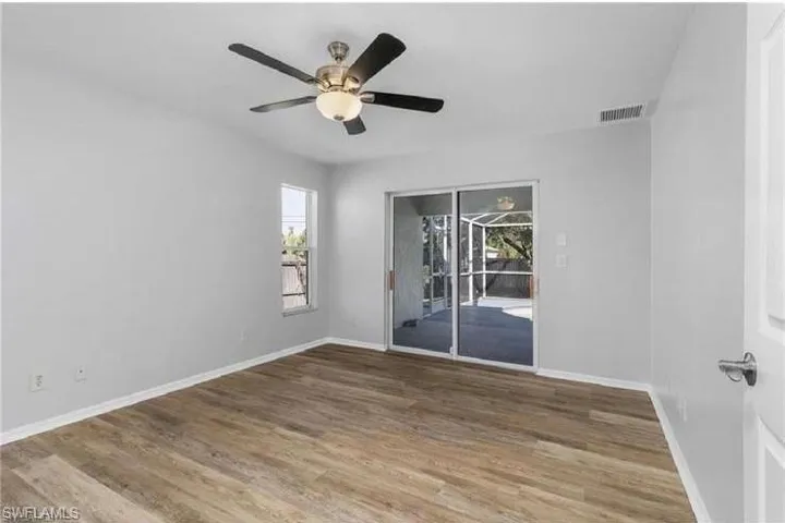 Unfurnished room featuring plenty of natural light, wood finished floors, and ceiling fan