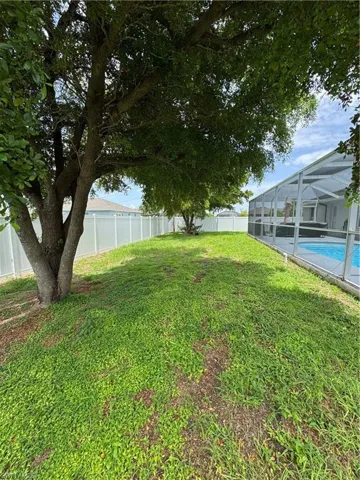 Fenced backyard with a lanai