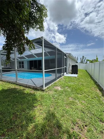 Back of house featuring a fenced backyard and a lanai
