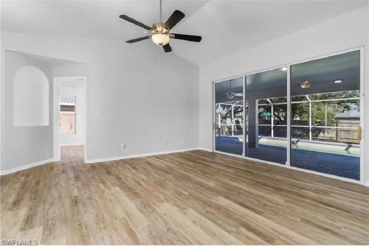Spare room featuring ceiling fan, wood finished floors, and high vaulted ceiling