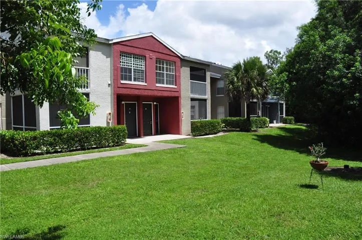 View of front facade featuring a balcony and a front lawn