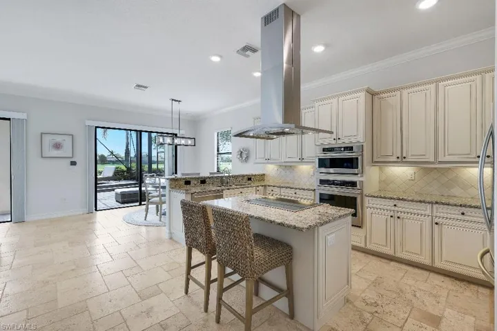 Kitchen featuring light-toned cabinetry, stainless steel appliances, granite countertops, and a tile backsplash