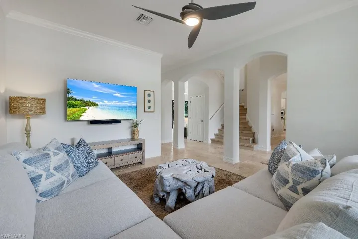 Living space featuring cased archways, a contemporary ceiling fan, and light-toned flooring