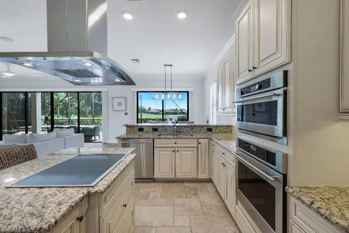 Gourmet kitchen featuring granite countertops, stainless steel appliances, white cabinetry, and tile flooring