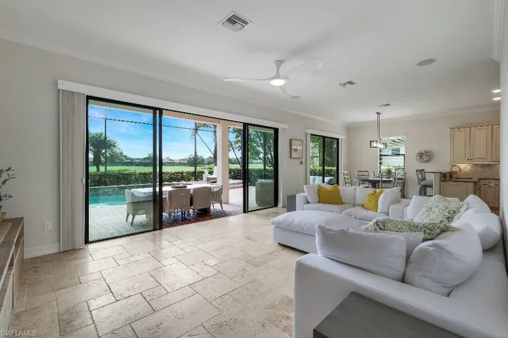 Spacious living area featuring large format tile flooring, a ceiling fan, and recessed lighting