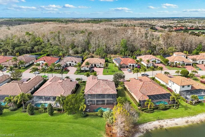 Aerial perspective showcasing a residential community with tiled-roof homes, individual screened pools, and manicured landscaping