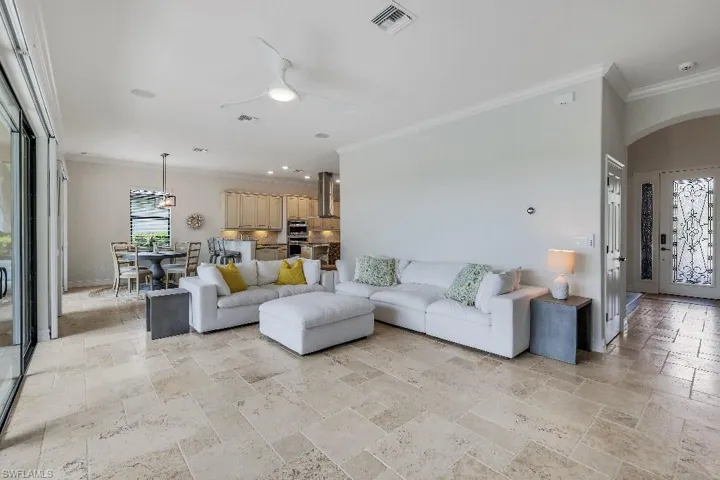 Open concept living area featuring light-toned tile flooring, recessed lighting, and a modern ceiling fan