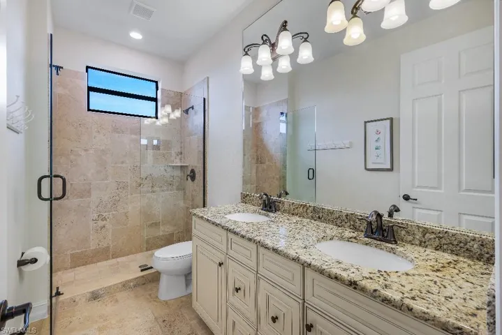 Bathroom featuring a dual vanity with granite countertop, undermount sinks, and oil-rubbed bronze fixtures
