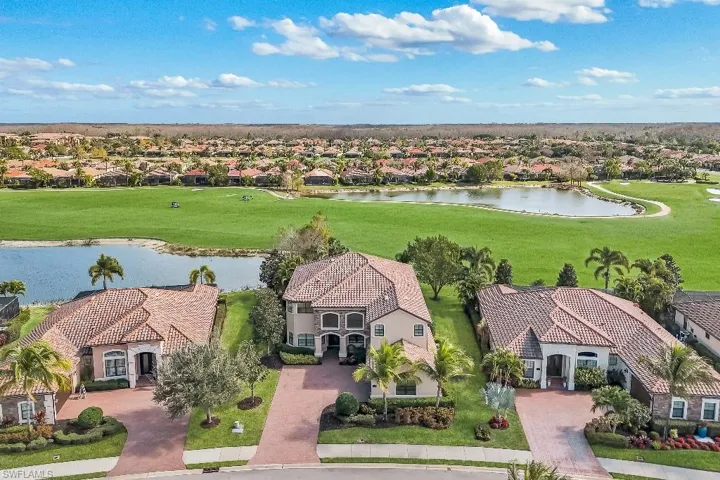 Resort-style neighborhood featuring a lake and golf course backdrop
