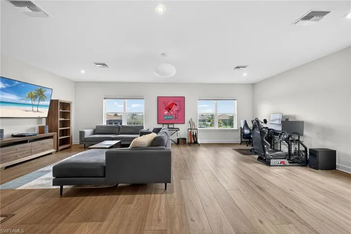 Living room with light wood finished floors and recessed lighting
