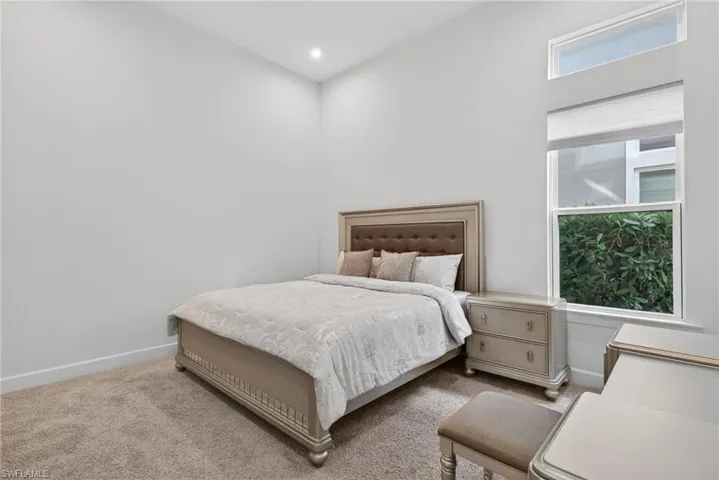 Carpeted bedroom with baseboards and recessed lighting