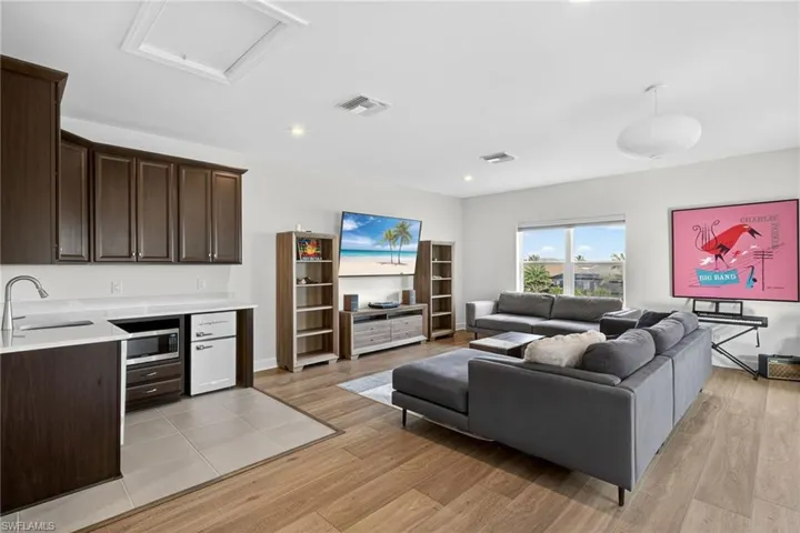 Living area with light wood-type flooring and recessed lighting