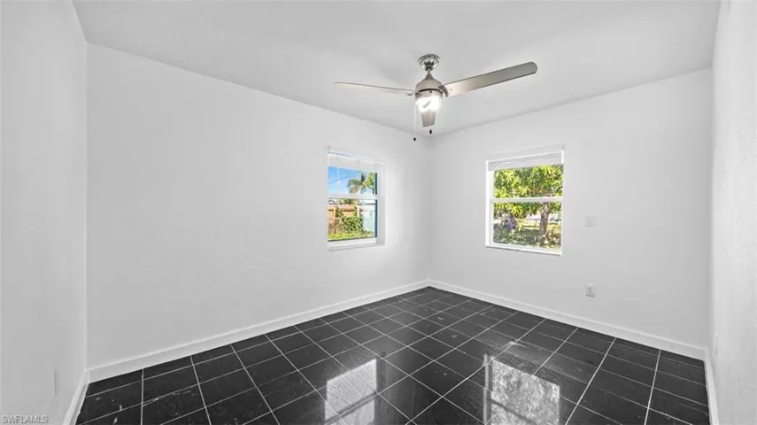 Spare room featuring baseboards and ceiling fan