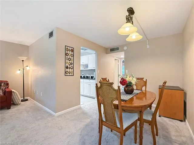 Dining room with baseboards, and light carpet