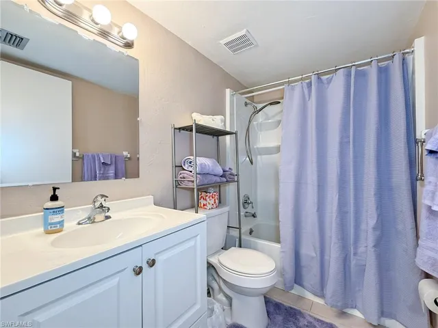 Bathroom featuring tile patterned floors, visible vents, toilet, and vanity