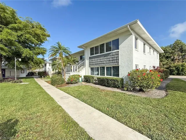 View of front of house with stucco siding and a front lawn