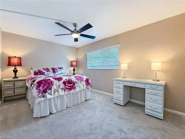 Bedroom featuring light carpet, baseboards, and a ceiling fan