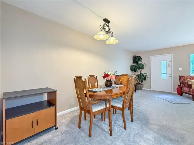 Dining area featuring baseboards and light colored carpet