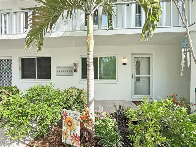 View of exterior entry featuring a balcony and stucco siding