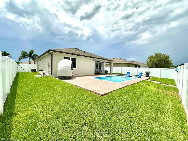 Rear view of property featuring stucco siding, a patio, and a fenced backyard