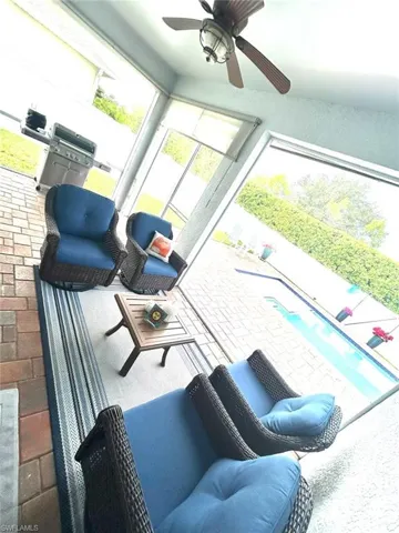 Sunroom / solarium featuring ceiling fan and a patio area