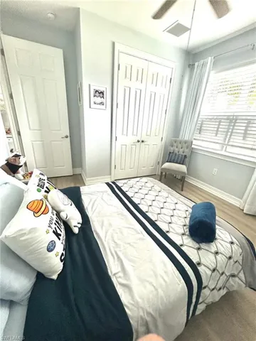 Bedroom with a closet, wood finished floors, and a ceiling fan