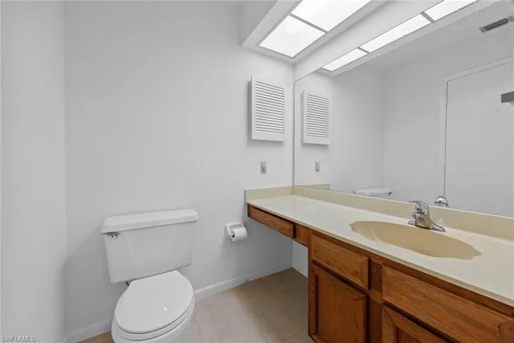 Bathroom with tile floors, large vanity, and toilet