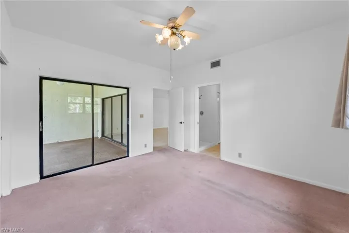 bedroom featuring sliding doors to lanai, a walk-in closet, ceiling fan, and carpet floors
