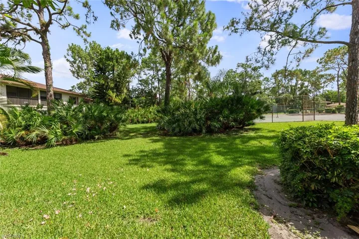 View from screened lanai - tennis court and landscaping