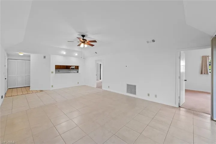 living room featuring light tile and ceiling fan