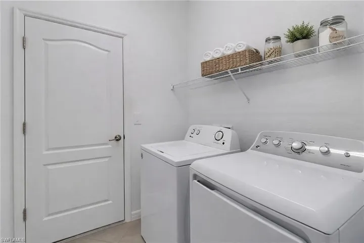Laundry room featuring washer and clothes dryer and light tile patterned floors