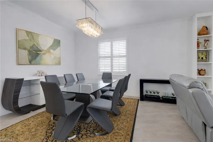 Dining room featuring hanging lights and crown molding
