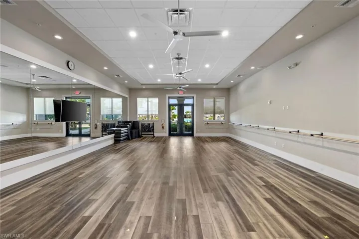 Exercise area with french doors, a drop ceiling, ceiling fan, and recessed lighting