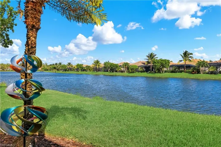 Waterfront parcel featuring a manicured lawn, palm trees, and expansive lake frontage