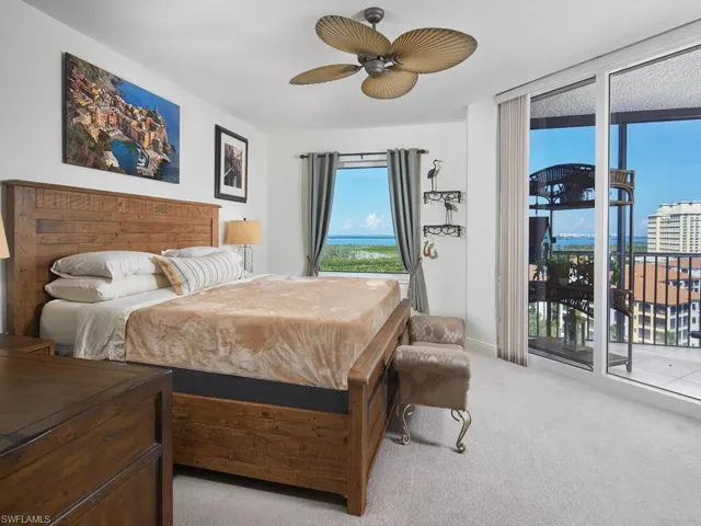 Bedroom featuring light carpet, ceiling fan, and access to exterior