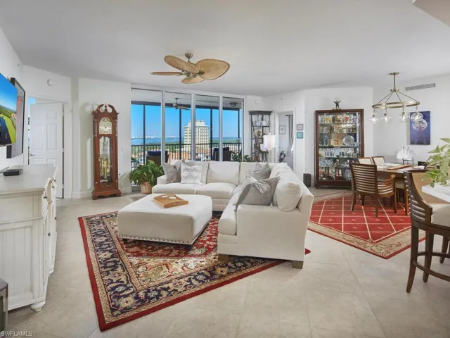Tiled living room with ceiling fan and a wall of windows