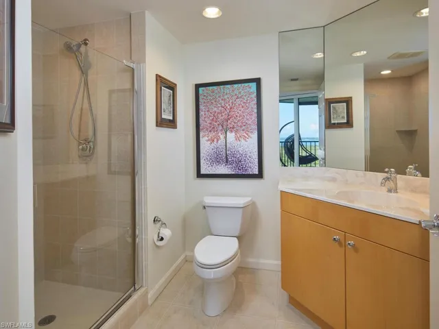 Bathroom with vanity, toilet, an enclosed shower, and tile patterned floors
