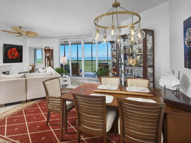 Dining area featuring ceiling fan with notable chandelier