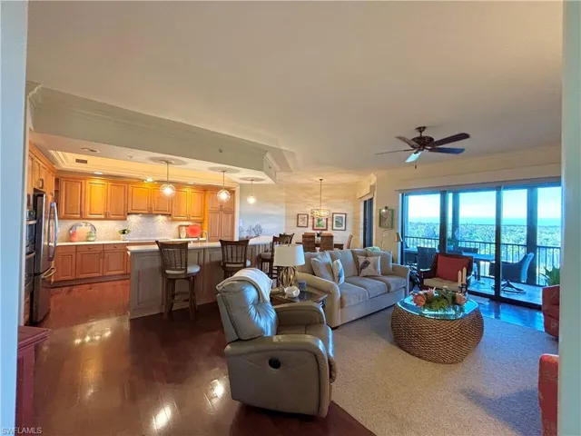 Living room featuring ceiling fan, crown molding, and dark hardwood / wood-style floors