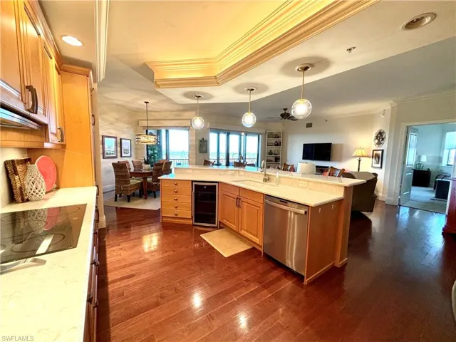 Kitchen featuring dark hardwood / wood-style flooring, wine cooler, stainless steel dishwasher, and crown molding