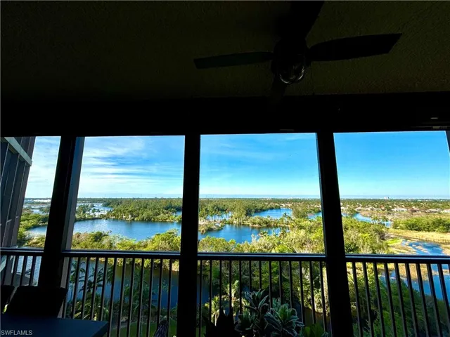 Unfurnished sunroom featuring ceiling fan and a water view