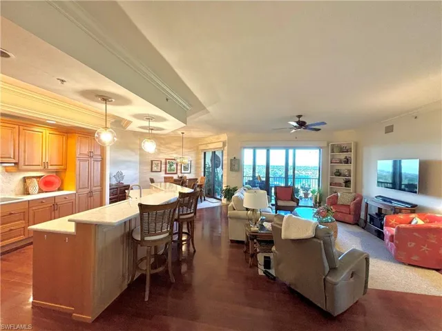 Living room featuring ceiling fan, dark hardwood / wood-style floors, and ornamental molding
