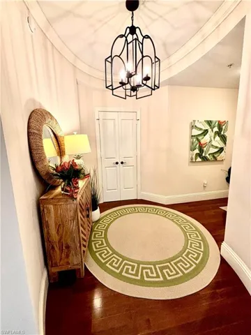 Entryway with dark hardwood / wood-style flooring and an inviting chandelier French Doors leading to Guest Suite