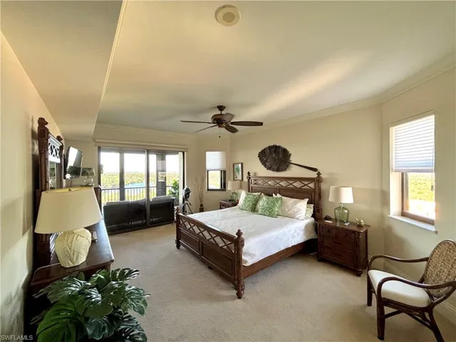 Master Carpeted bedroom with access to exterior, ceiling fan, and ornamental molding