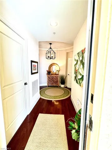 Corridor featuring dark hardwood / wood-style flooring and a chandelier