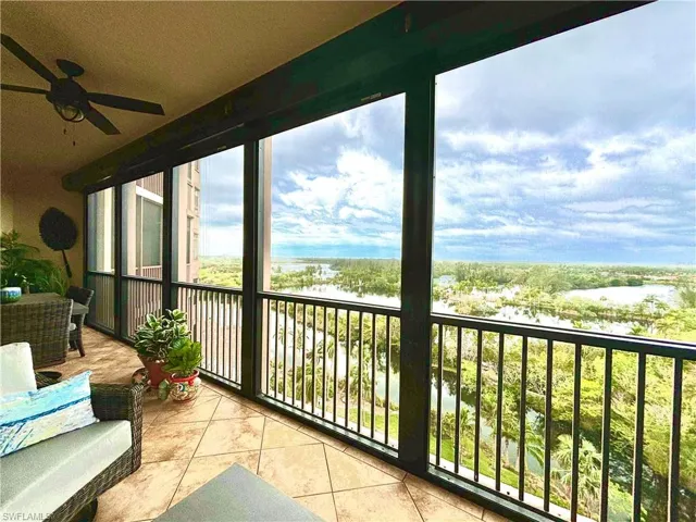 Balcony featuring ceiling fan and a water view