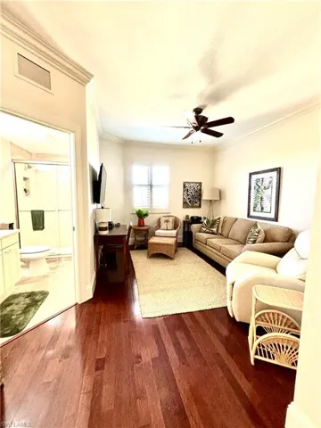 Guest Suite with ceiling fan, dark hardwood / wood-style floors, and ornamental molding
