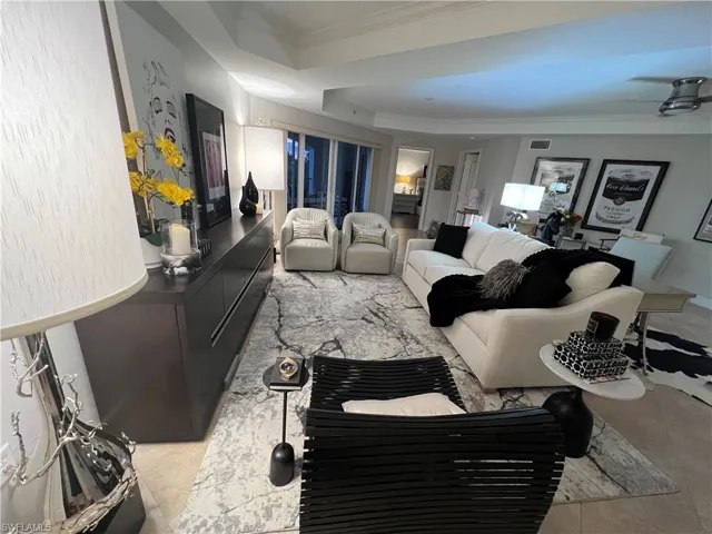 Living room featuring a tray ceiling and ornamental molding